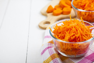 Grate  carrots in a bowl