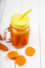 Carrot juice on a wooden table.