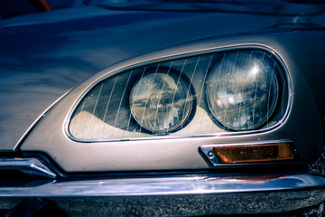 Fototapeta premium Close-up, detailed photo of the front, grille and head lamp of a classic oldtimer car