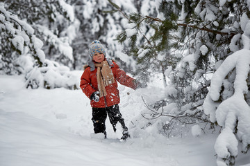 winter fun. the boy alone wanders through the winter snowy forest.