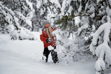 Fototapeta na wymiar winter fun. the boy alone wanders through the winter snowy forest.