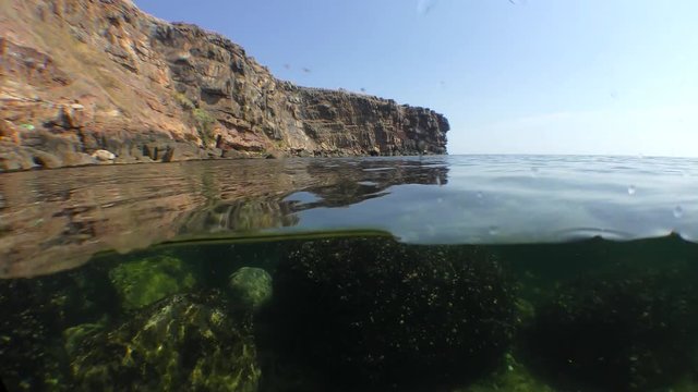 Split: rocky seashore from above, underwater rocks from below.
