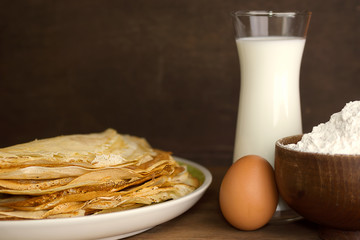 Stack of colorful russian crepes with milk, flour and egg. Traditional pancakes rustic background. Text space