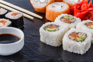 Sushi Set nigiri, sushi rolls and sashimi served on stone slate
