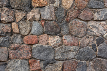 Stone wall made from irregular sized stone blocks.