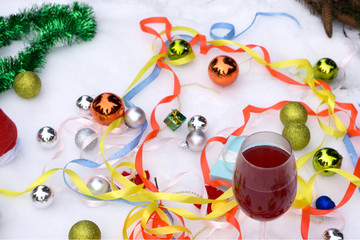 Two glasses of wine and gifts with a red satin ribbon, apples , pine cones, branches, gold ornaments garlands