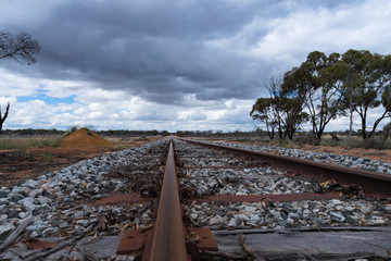 Blick &uuml;ber ein Bahngleis in die Ferne mit wolkigem Himmel
