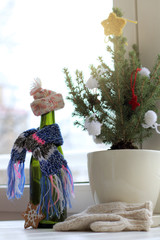 cozy atmosphere awaiting  holiday/ dressed up green bottle on the background of  real Christmas tree next to the window 