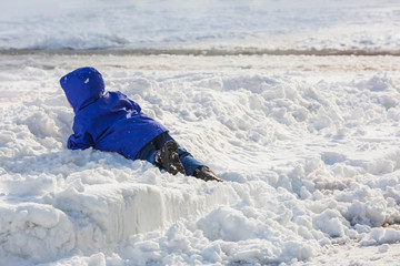 Fototapeta na wymiar Boy falls in the snow