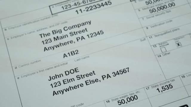 W2 tax form 2017 for man person John Doe turns with american usa flag. Wage and tax statement