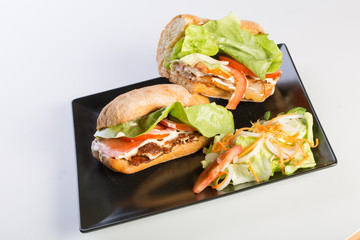 close up of BLT sandwich with salad on a black plate