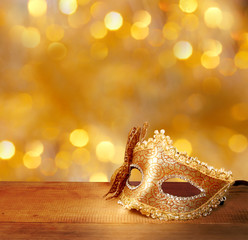Traditional female carnival venetian mask  on table .Masquerade  mask on  glitter background.Mardi...