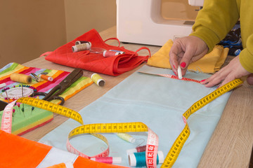 Female fashion designer working at studio with pattern cuttings and sketches