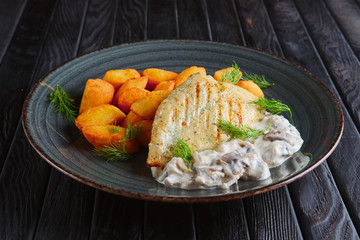 Rustic lunch. Grilled chicken filet with potato balls and creamy mushroom sause