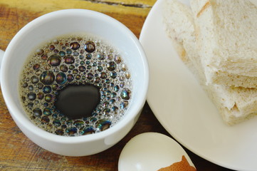tuna whole wheat sandwich on plate and boiled egg eat couple with black coffee cup
