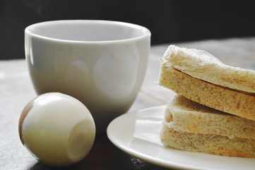tuna whole wheat sandwich on plate and boiled egg eat couple with black coffee cup