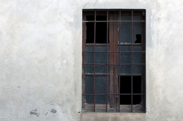 Fototapeta na wymiar old broken window with a metal lattice