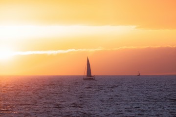 Naklejka na ściany i meble Beautiful sunset at the sea with sailing boat