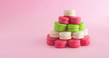 Colorful french macarons on a pink background for Christmas celebration