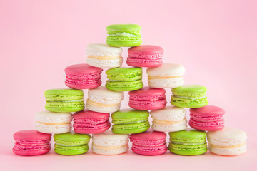 Colorful french macarons on a pink background for Christmas celebration