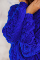 detail of a fashionable woman wearing a navy blue oversized sweater, close up