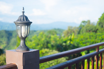 Outdoor old lantern on green nature in the park background.
