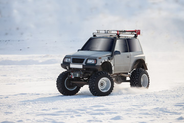 Off-road car with big wheels drives on snow