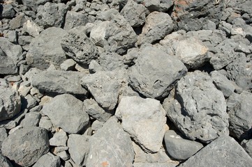 A closeup picture of a pile of grey stones. 