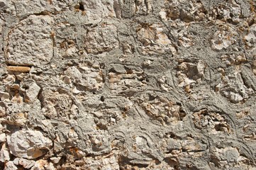 Genoese fortress wall fragment. Old stonewall. Textured background. Rocks and concrete.