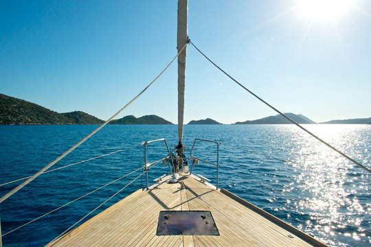 Front deck of a sailing yacht with beautiful sea and islands in the background.