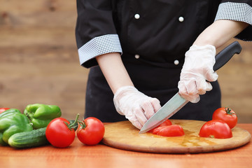 The cook cuts fresh farm vegetables
