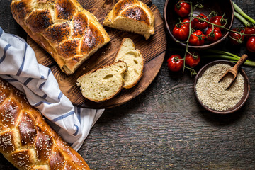 Challah is a Jewish bread to the feast on the dark wooden boards.