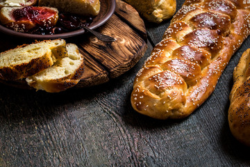 Challah is a Jewish bread to the feast on the dark wooden boards.