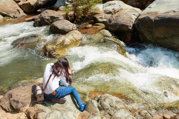 Woman hiking around mountains near the river at spring time.