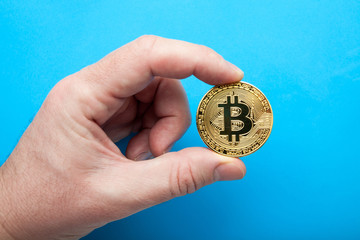 Crypto currency The bitcoin in hand on a blue background.