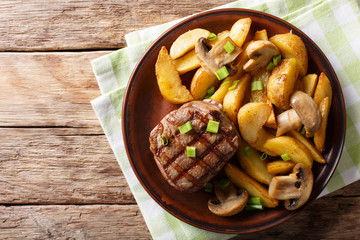Grilled fillet mignon with potatoes and mushrooms close-up. Horizontal top view