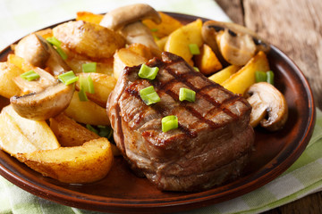 Homemade fillet mignon with fried potatoes and mushrooms close-up. horizontal