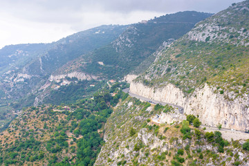 Fototapeta premium Daylight foggy view to Eze village, trees and mountains