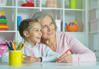 Fototapeta premium Grandmother with granddaughter drawing together