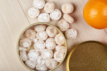 Candies sprinkled with powdered sugar in a metal jar.