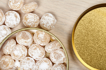 Candies sprinkled with powdered sugar in a metal jar.