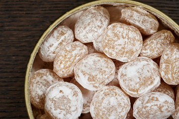 Candies sprinkled with powdered sugar in a metal jar.