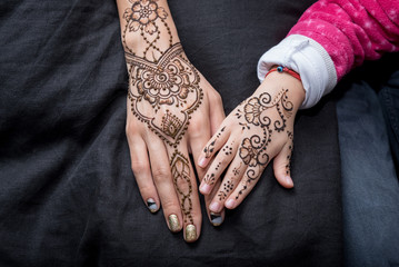 Picture of human hand being decorated with henna