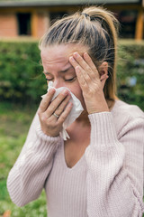 Young woman blowing her nose. allergic rhinitis. Woman has sneezing