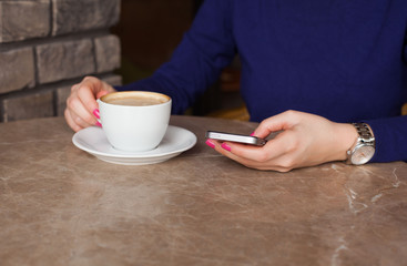 Woman texting message in cafe