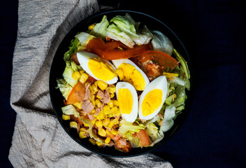 Delicious fresh salad with tomatoes, lettuce, eggplant, zucchini, cheese, parma ham and olive oil.