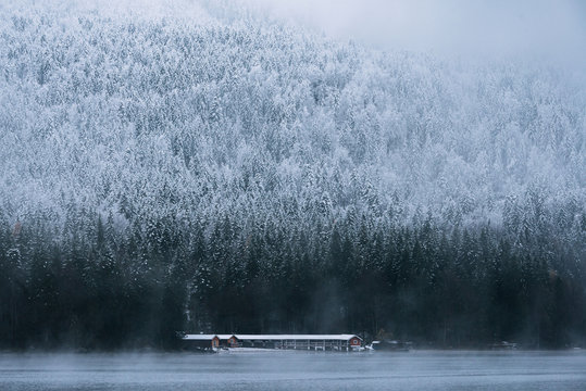 Boat house at Lake Eibsee with pine forest during early winter on a blue hour moody day, bavaria, Germany