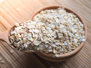 Healthy eating concept. Dry rolled oatmeal in bowl and spoon.
