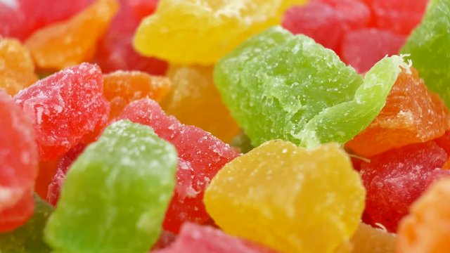 Rotates plate with colorful cubes candied fruit on white background. Macro Turkish Delight. Closeup concept as Background