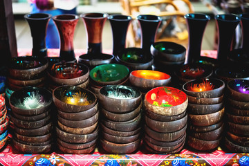 Coconut shell bowls on the wooden shelf. Souvenir coconut bowls selling on the market